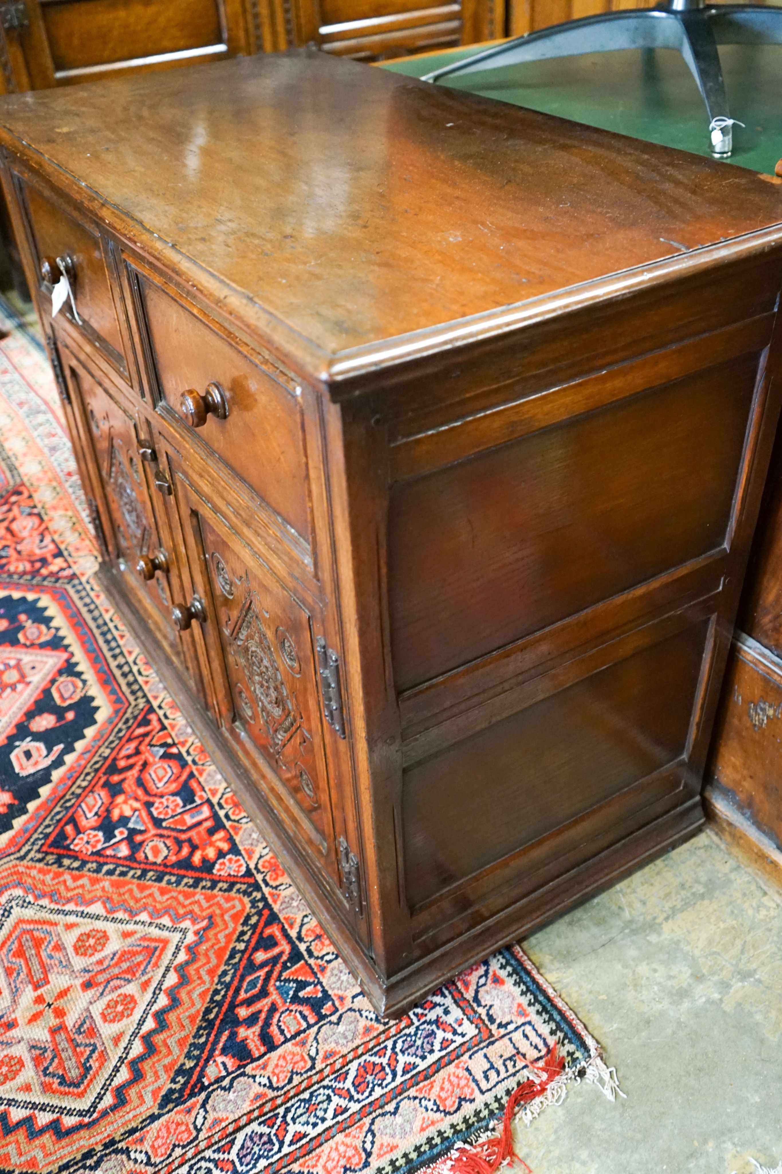 A 17th century style carved and panelled oak cupboard